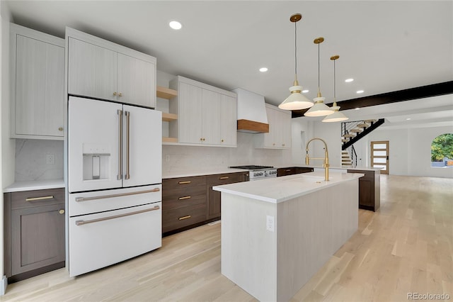 671 Elati St, Denver, CO 80204 - kitchen with high end appliances, open shelves, light wood-style floors, recessed lighting, and a center island with sink
