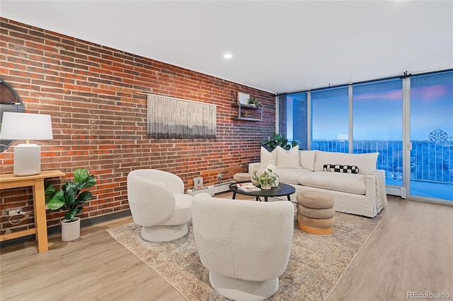 living room with brick wall, a baseboard heating unit, wood finished floors, and recessed lighting