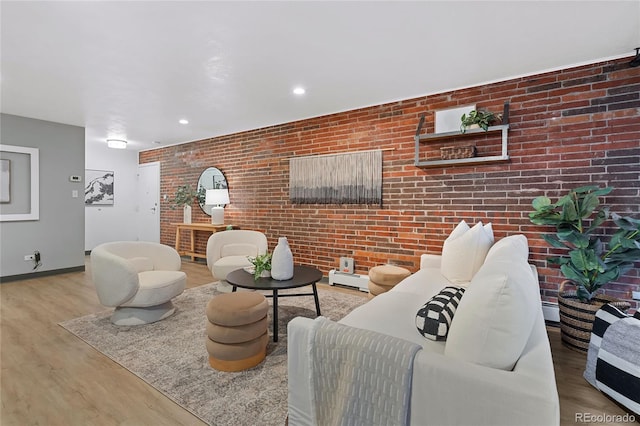 living area with baseboards, a baseboard radiator, brick wall, wood finished floors, and recessed lighting