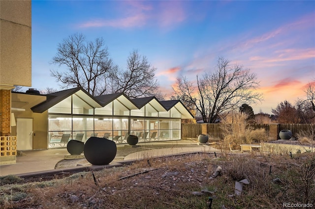 rear view of property featuring a patio and fence