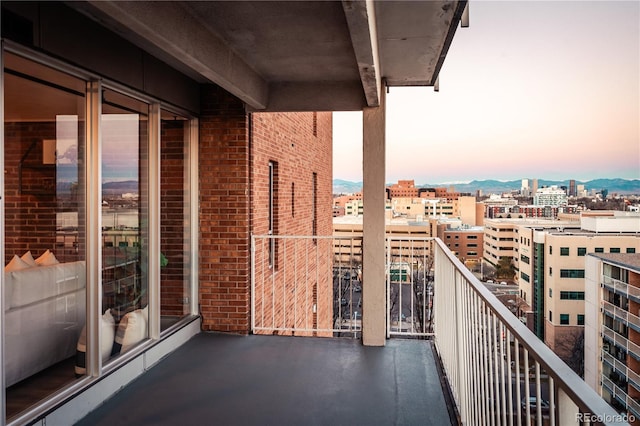 balcony at dusk featuring a view of city