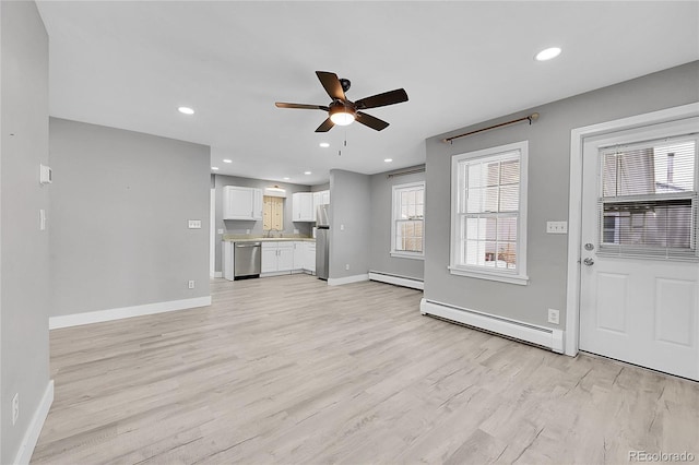 unfurnished living room with a baseboard radiator, light hardwood / wood-style floors, and ceiling fan