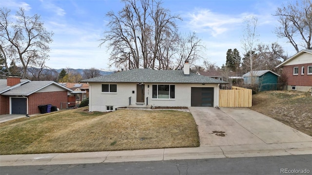 ranch-style house with an attached garage, a chimney, a front lawn, concrete driveway, and brick siding