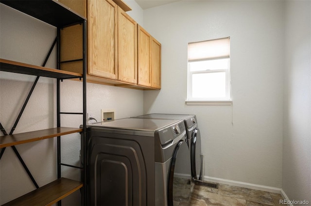 washroom with cabinet space, independent washer and dryer, and baseboards