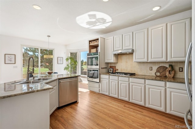 kitchen featuring sink, appliances with stainless steel finishes, decorative light fixtures, and white cabinets