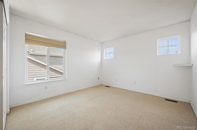 unfurnished room with baseboards, visible vents, and carpet