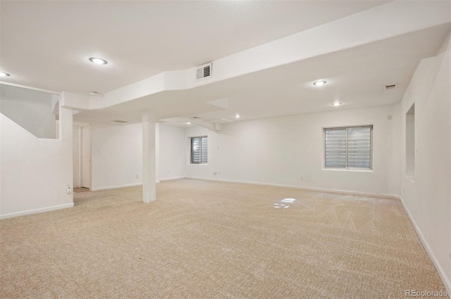 below grade area featuring baseboards, recessed lighting, light carpet, and visible vents
