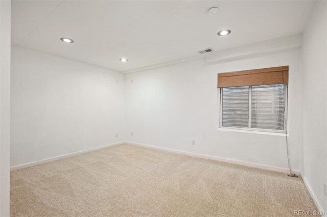 carpeted spare room featuring visible vents, baseboards, and recessed lighting