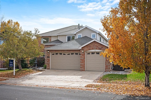view of front of property featuring a shingled roof, concrete driveway, brick siding, and a garage