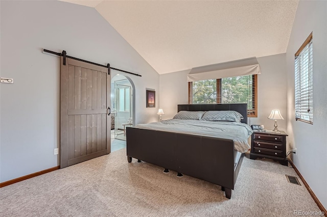 bedroom featuring lofted ceiling, light carpet, and a barn door