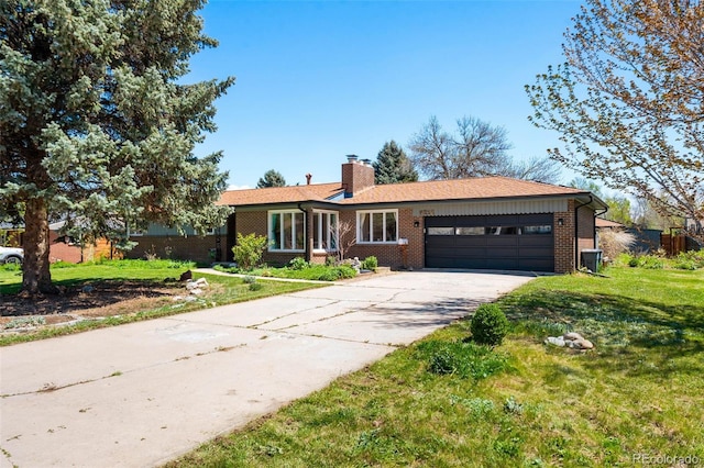 ranch-style home featuring an attached garage, brick siding, a chimney, a front yard, and driveway