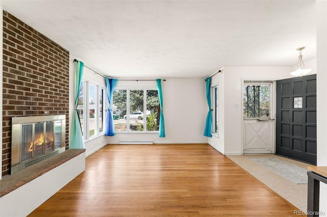 foyer entrance featuring wood finished floors, a fireplace, and plenty of natural light