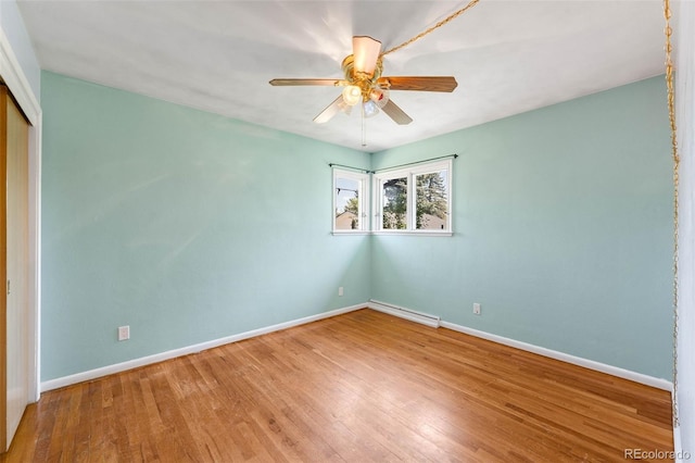 unfurnished room featuring baseboards, wood finished floors, ceiling fan, and a baseboard radiator