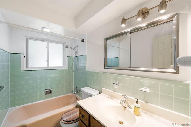 bathroom with toilet, shower / bathtub combination, vanity, and tile walls