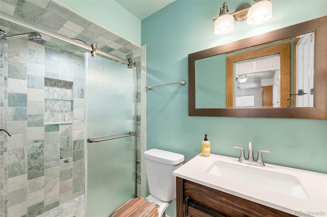 bathroom featuring a shower stall, toilet, and vanity