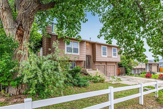 9832 High St, Thornton, CO 80229 - bi-level home with concrete driveway, an attached garage, brick siding, and a chimney