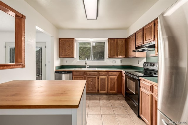 9832 High St, Thornton, CO 80229 - kitchen with stainless steel appliances, a sink, under cabinet range hood, wooden counters, and light tile patterned flooring