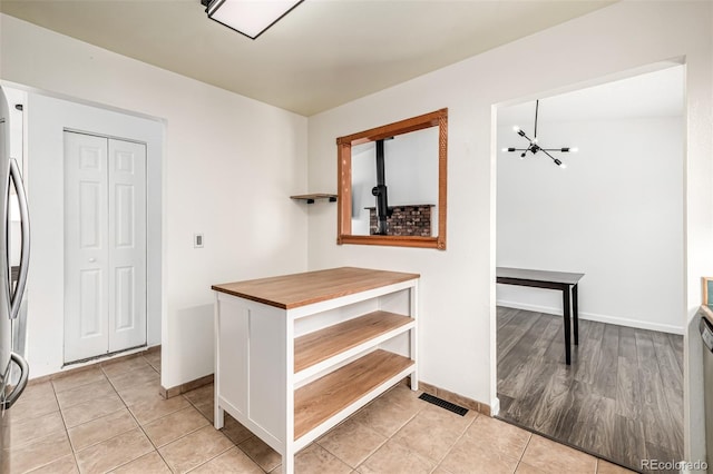 9832 High St, Thornton, CO 80229 - corridor with light tile patterned floors, a chandelier, and baseboards