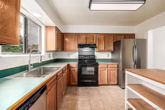 9832 High St, Thornton, CO 80229 - kitchen with stainless steel appliances, under cabinet range hood, a sink, brown cabinets, and light countertops