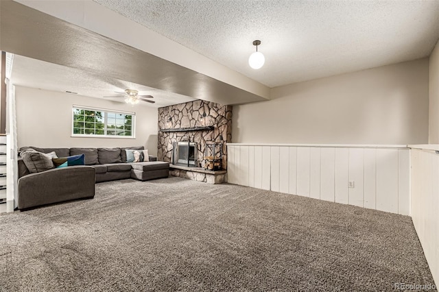 9832 High St, Thornton, CO 80229 - living room with a textured ceiling, carpet floors, ceiling fan, a stone fireplace, and wainscoting