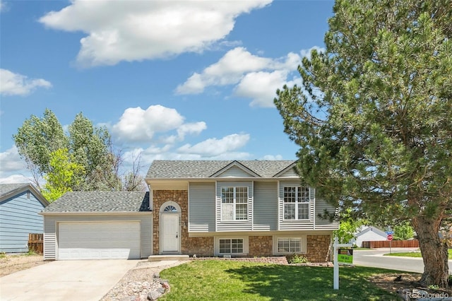 5886 S Nepal Way, Centennial, CO 80015 - split level home featuring an attached garage, concrete driveway, a shingled roof, and stone siding