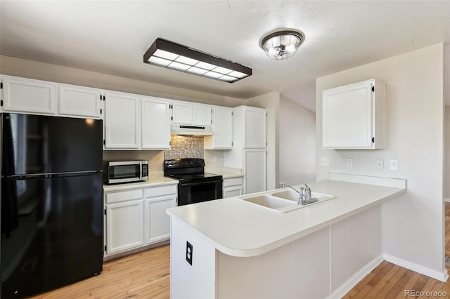 5886 S Nepal Way, Centennial, CO 80015 - kitchen featuring black appliances, under cabinet range hood, light wood-type flooring, white cabinetry, and a sink