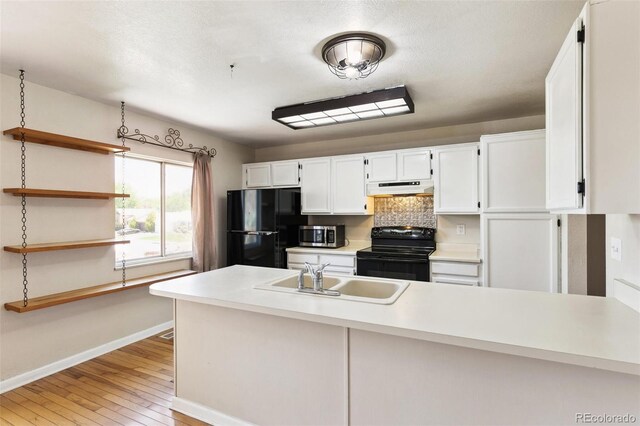 5886 S Nepal Way, Centennial, CO 80015 - kitchen with black appliances, under cabinet range hood, a sink, baseboards, and white cabinetry