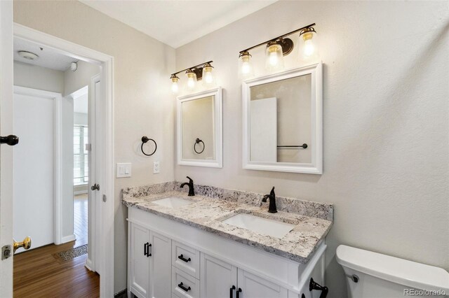 5886 S Nepal Way, Centennial, CO 80015 - bathroom featuring double vanity, toilet, and wood finished floors
