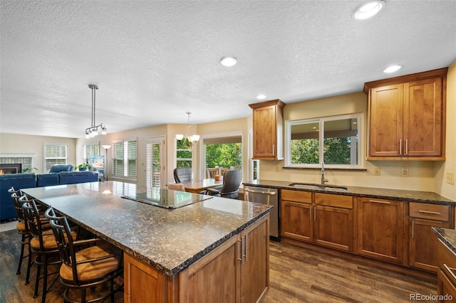 kitchen with dark hardwood / wood-style flooring, a center island, an inviting chandelier, black electric cooktop, and stainless steel dishwasher