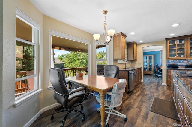 dining room featuring dark hardwood / wood-style floors, sink, and a notable chandelier