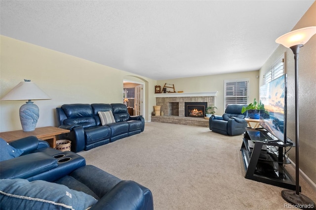 carpeted living room featuring a textured ceiling and a fireplace