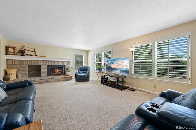 living room featuring a brick fireplace, a textured ceiling, plenty of natural light, and carpet