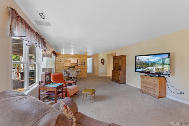 living room featuring light carpet and wood walls