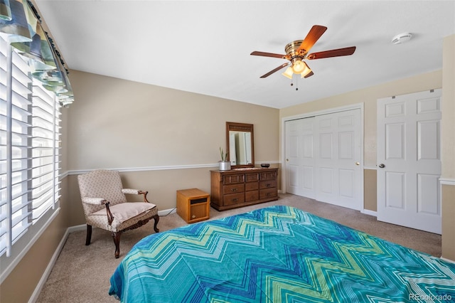 carpeted bedroom with a closet, ceiling fan, and multiple windows