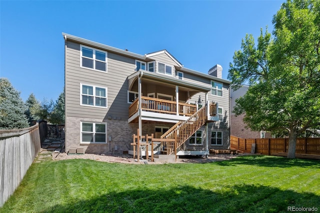 rear view of house with a wooden deck, a patio area, and a yard