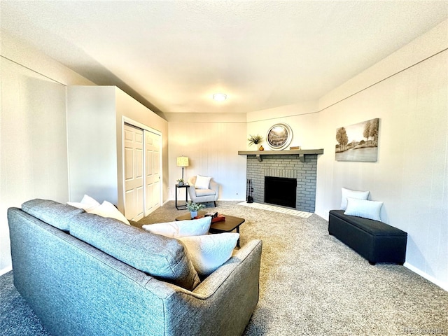 living room featuring carpet flooring, a textured ceiling, and a brick fireplace