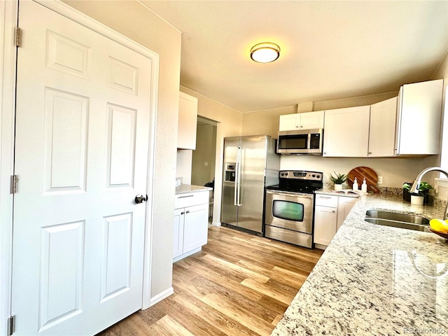 kitchen featuring light hardwood / wood-style floors, sink, white cabinetry, and stainless steel appliances