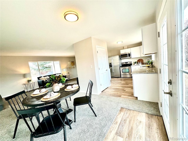 dining area featuring sink and light wood-type flooring