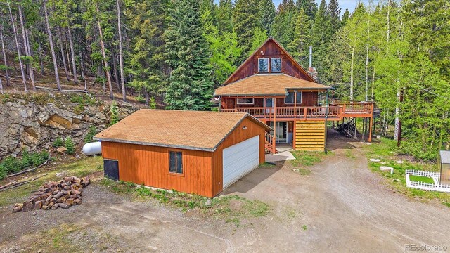 80 Castlewood Ct, Evergreen, CO 80439 - chalet / cabin with a deck, a garage, an outbuilding, and a view of trees
