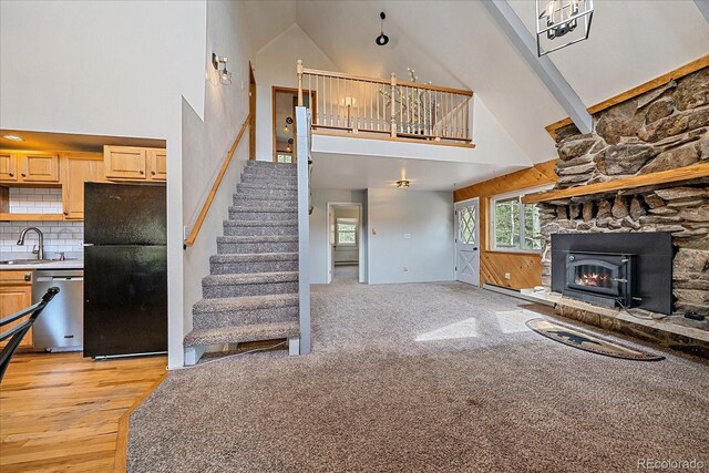 80 Castlewood Ct, Evergreen, CO 80439 - unfurnished living room featuring high vaulted ceiling, a sink, a fireplace, stairs, and light wood-style flooring