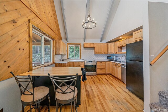 80 Castlewood Ct, Evergreen, CO 80439 - kitchen with appliances with stainless steel finishes, light countertops, light wood finished floors, decorative backsplash, and a chandelier