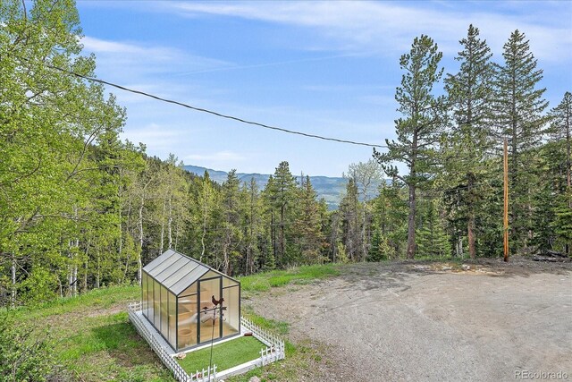80 Castlewood Ct, Evergreen, CO 80439 - view of street featuring a view of trees and a greenhouse
