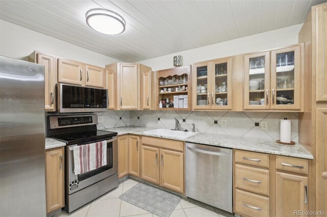 625 S Clinton St Unit 7A, Denver, CO 80247 - kitchen featuring stainless steel appliances, a sink, decorative backsplash, light stone counters, and light tile patterned floors