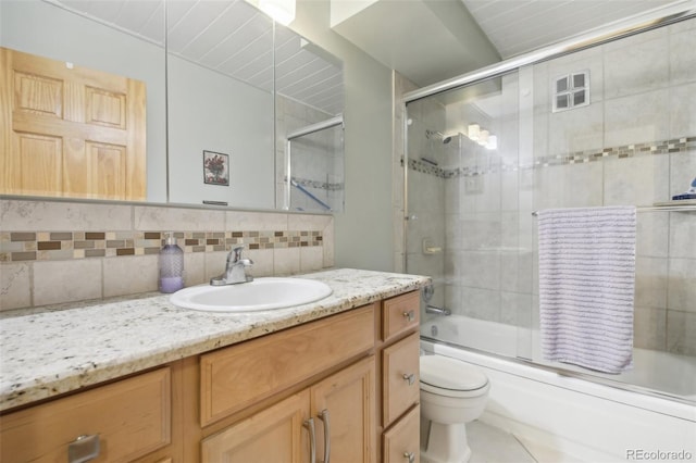625 S Clinton St Unit 7A, Denver, CO 80247 - full bathroom with vanity, toilet, decorative backsplash, and bath / shower combo with glass door