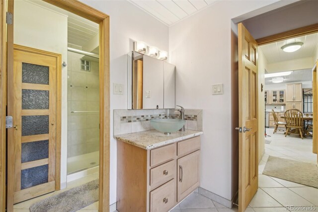 625 S Clinton St Unit 7A, Denver, CO 80247 - bathroom with tile patterned flooring, a stall shower, vanity, and tasteful backsplash
