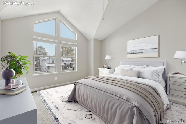 carpeted bedroom with a textured ceiling and high vaulted ceiling