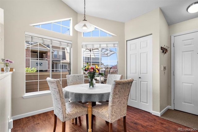 dining area featuring baseboards, dark wood-style floors, and high vaulted ceiling