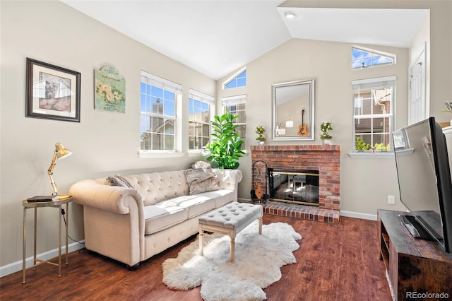 living area featuring vaulted ceiling, wood finished floors, a brick fireplace, and baseboards