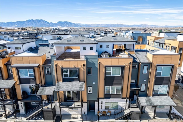 townhome / multi-family property with a mountain view, a residential view, and roof with shingles