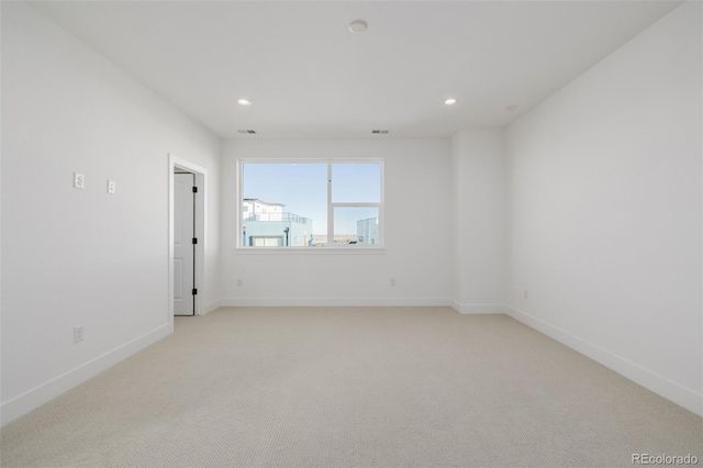 empty room with recessed lighting, visible vents, light colored carpet, and baseboards
